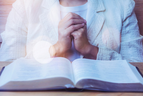 Close,up,of,woman,hands,praying,to,god,while,reading